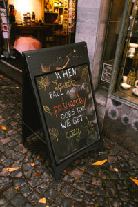 Kundenstopper in Monschau, Deutschland mit Aufschrift "When leaves fall and the patriarchy does too, we get cozy"